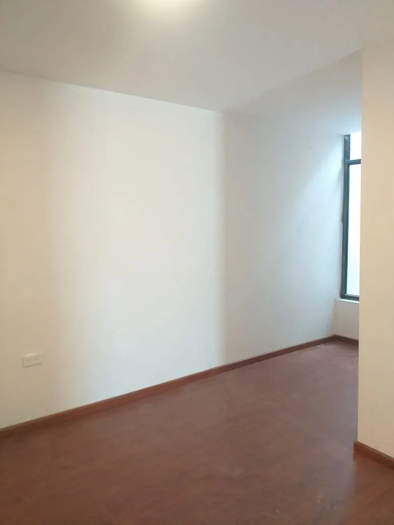 Sala con piso de madera y luz natural en la casa Pinar