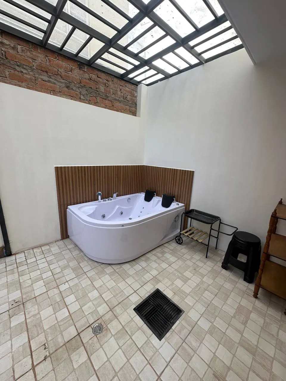 Jacuzzi bajo tragaluz con acabados de madera en una casa de Los Prematuros